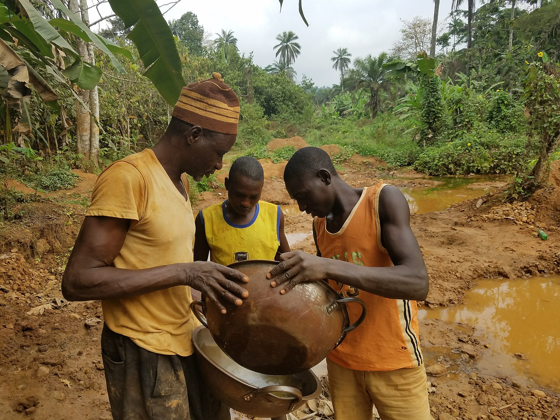 Artisanal miners in Itagun, Osun State, Nigeria, gather gold in a pan in a 2017 file photograph.